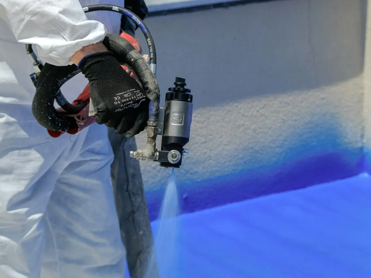 Professional brengt een coating aan met een spuitpistool